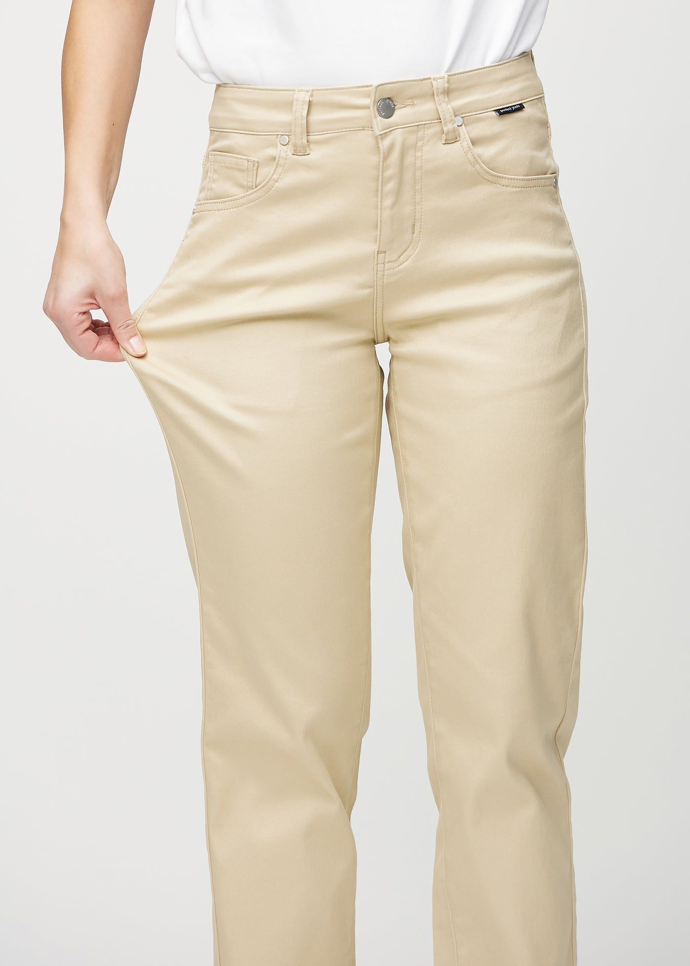 Model strækker jeansene ved låret for at vise stretch.