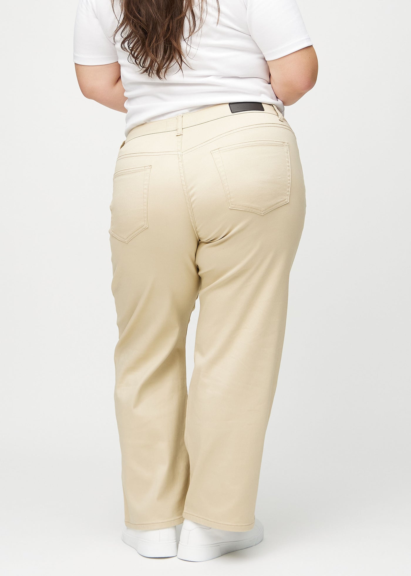 Beige loose jeans set bagfra på en plus-size model, så man kan se hele produktet.