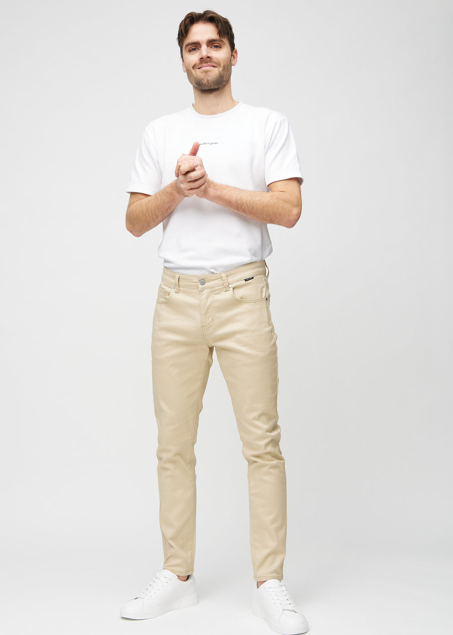 Fuldt billede af model i beige slim jeans.