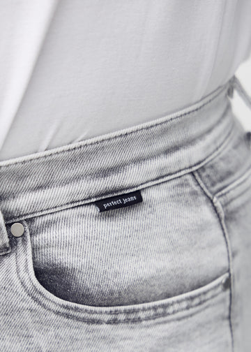 Forlommen på de lysegrå denim i farven Ashes – med tydeligt logo og syninger i fokus.