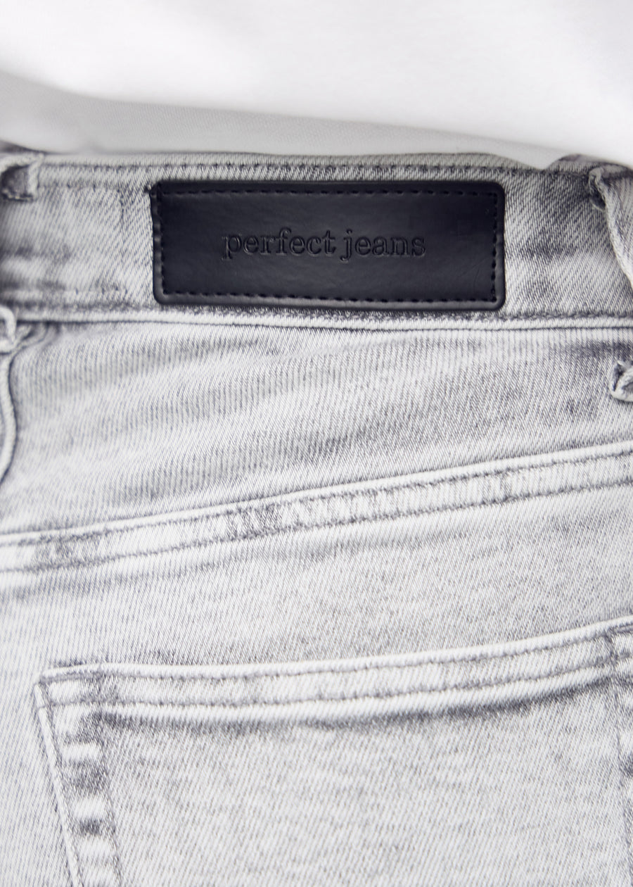 Nærbillede af lysegrå denim med Perfect Jeans læderpatch bagpå i taljen.