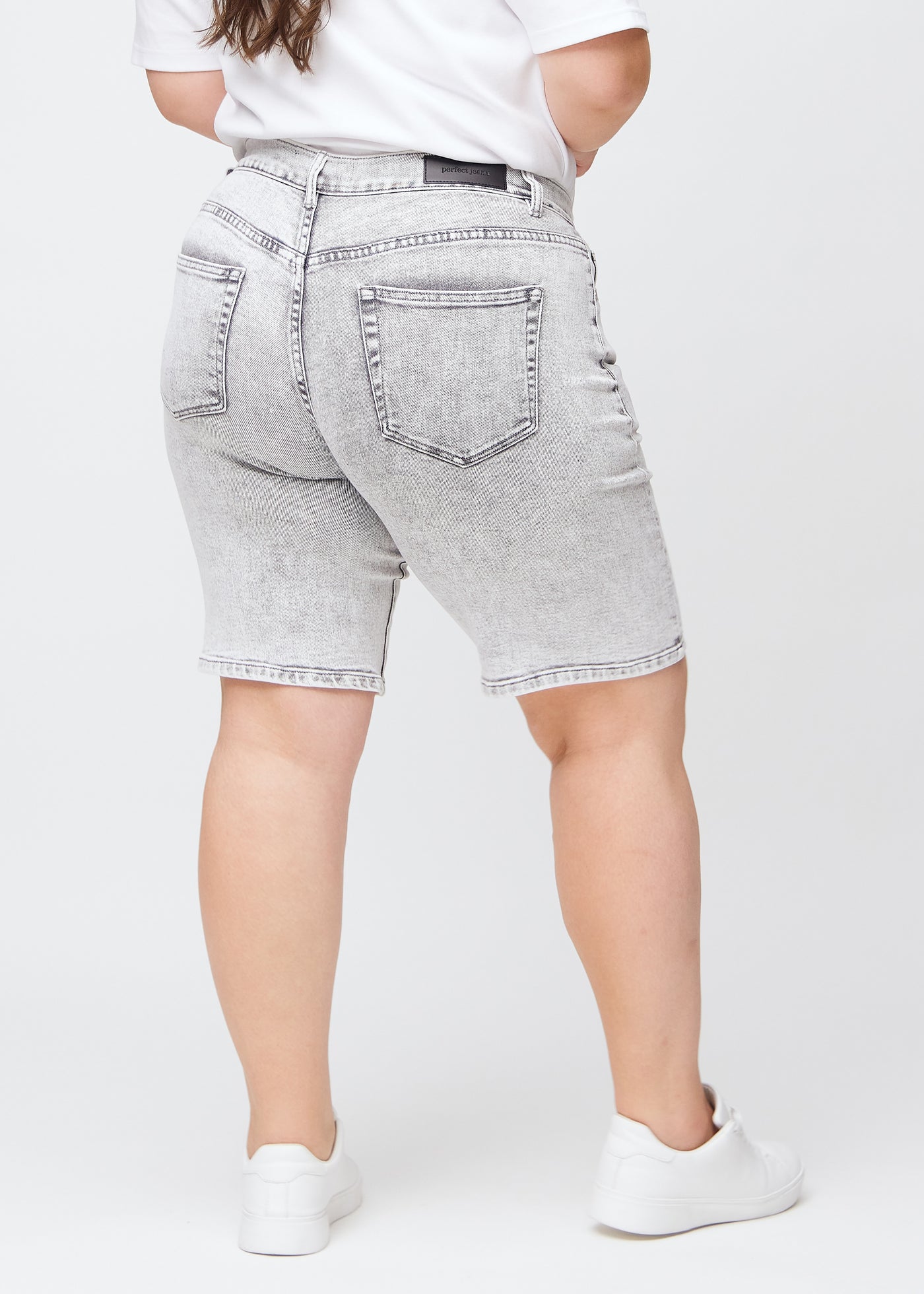 Lysegrå denim regular middle shorts set bagfra på en plus-size model, så man kan se hele produktet.