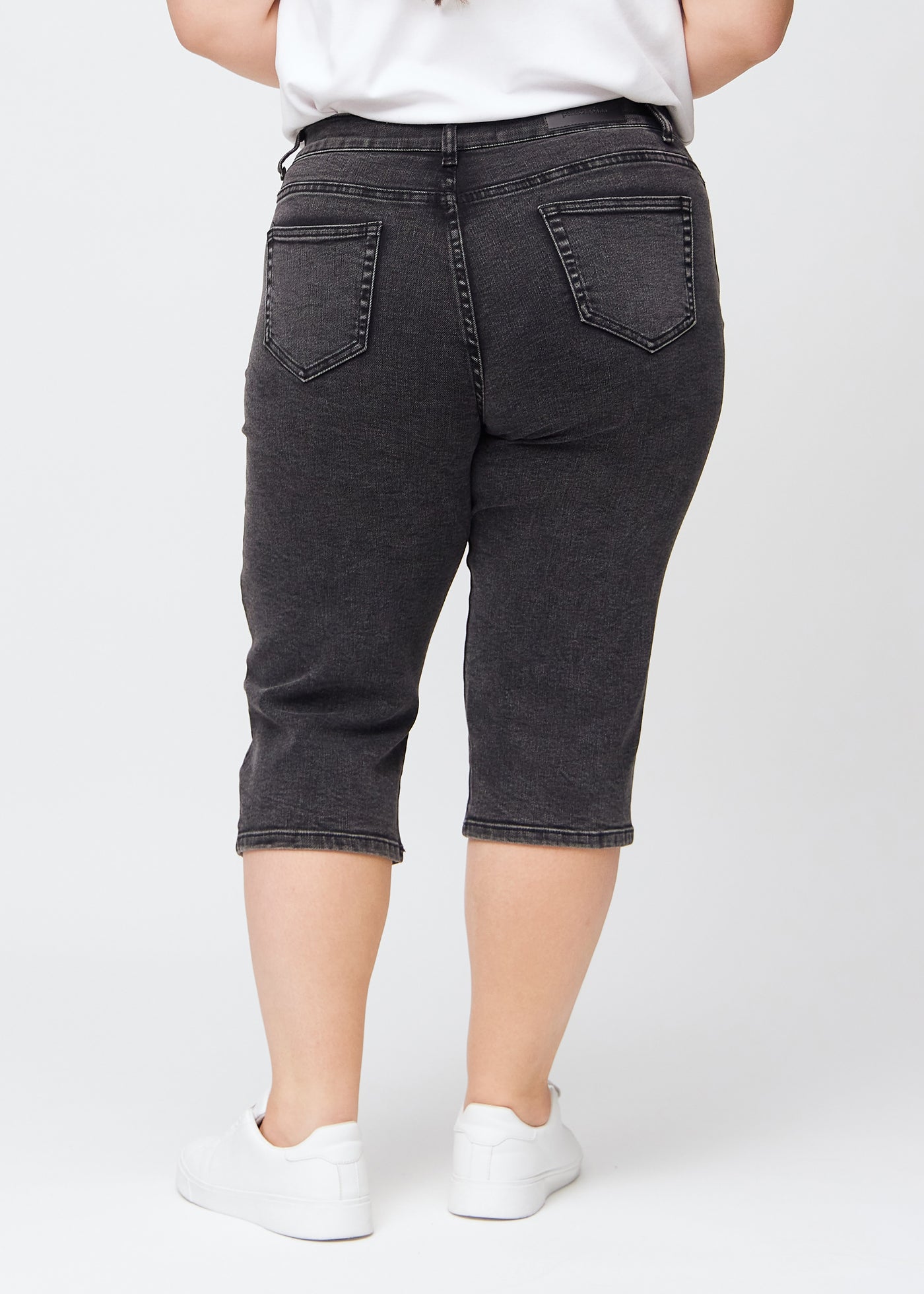 Mørkegrå denim regular capris set bagfra på en plus-size model, så man kan se hele produktet.