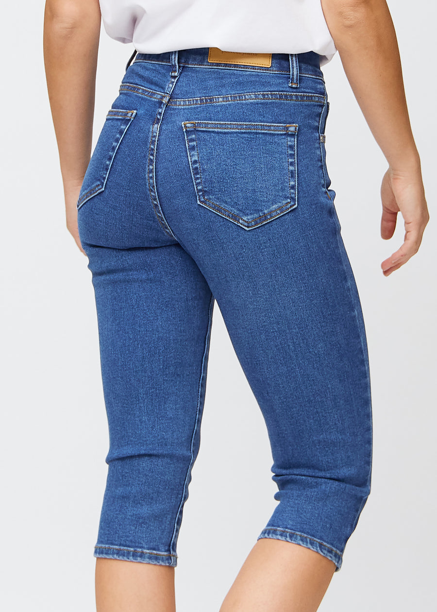 Tæt billede af de mørkeblå denim slim capris bagfra, så man tydeligt kan se detaljer og lommer.