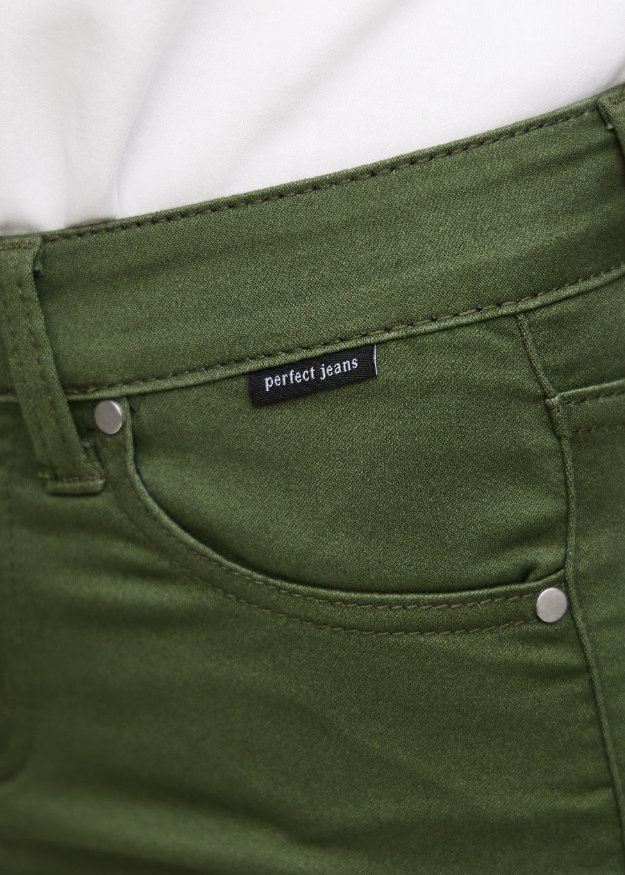 Nærbillede af grønt jeansmateriale med Perfect Jeans logoetiket ved forlommekanten.