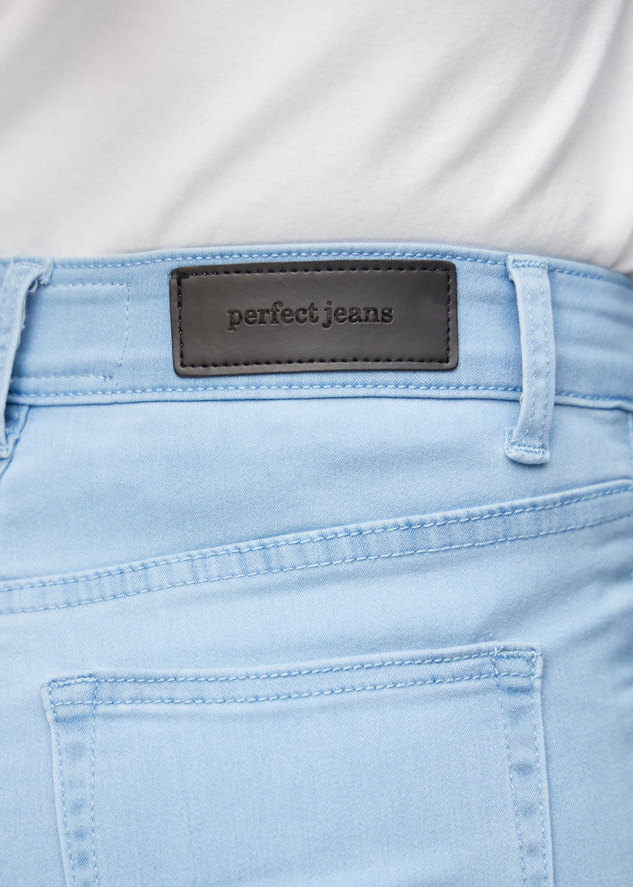 Nærbillede af lyseblåt jeansmateriale med Perfect Jeans læderpatch bagpå i taljen.