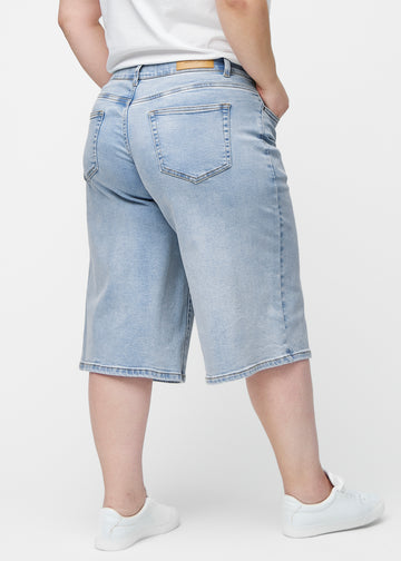 Loose, light blue denim capris in the colour Waves seen from the back on a plus-size model, showing fit and length.