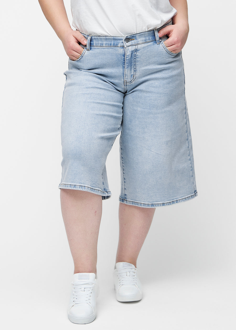 Loose, light blue denim capris in the colour Waves seen from the front on a plus-size model, sitting at the hips and falling loosely.