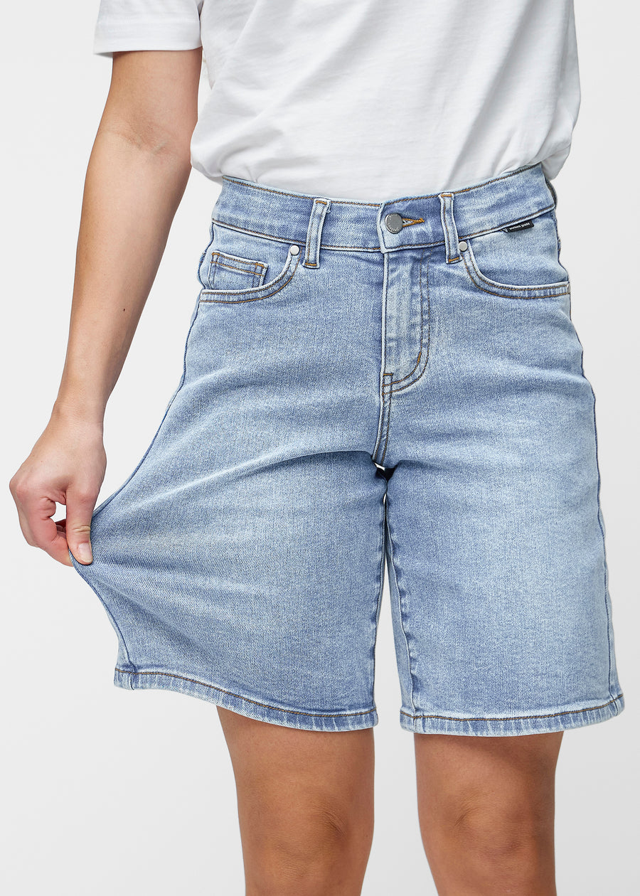 Loose, light blue denim shorts in the colour Waves, sitting at the hips and falling loosely over the thighs to just above the knee, seen from the front.