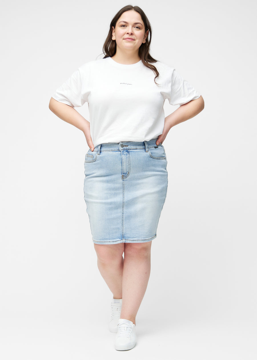 Fuldt billede af plus-size model i lyseblå, tætsiddende og knælang denimnederdel.