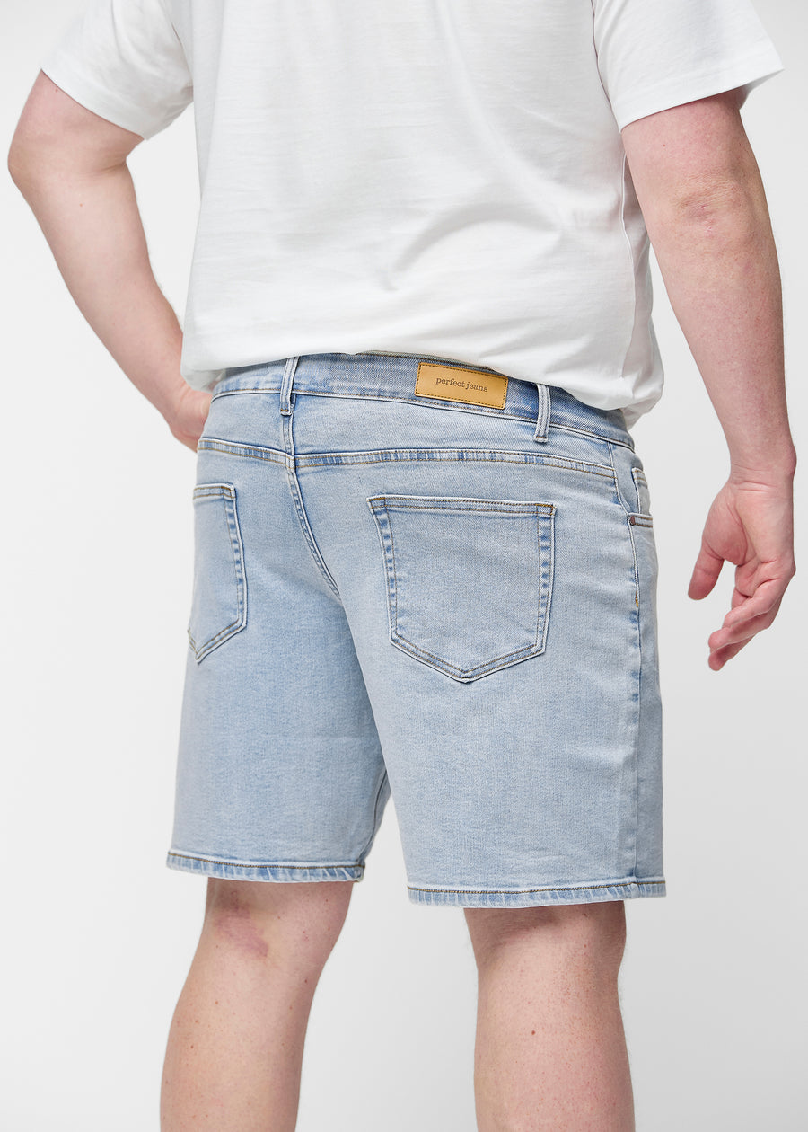 Light blue denim shorts for men in the colour Waves seen from the back up close on a plus-size model to show fit and details.