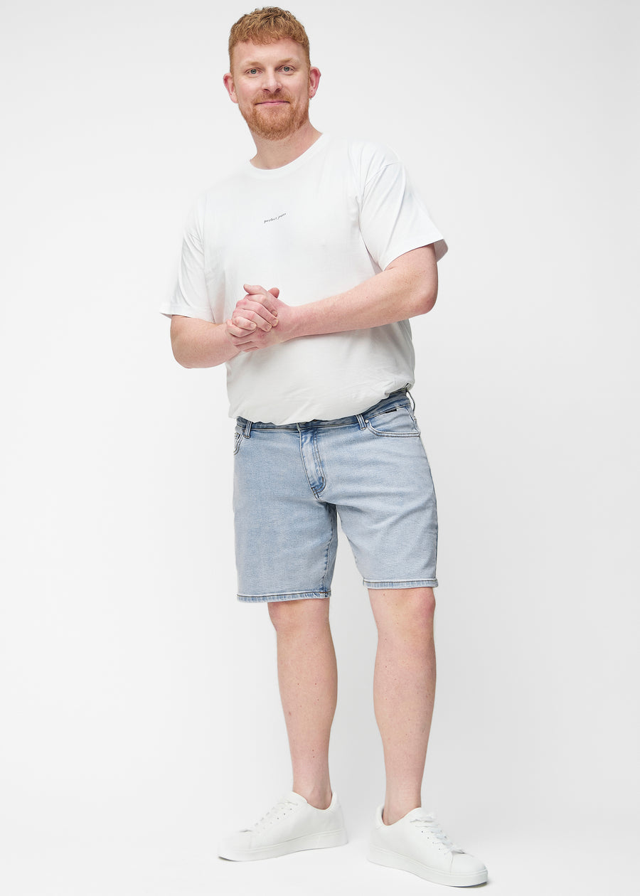 Full image of a plus-size model wearing light blue denim shorts for men in the colour Waves with a regular fit.