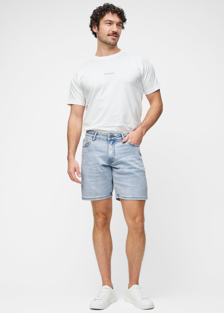 Full image of a model wearing light blue denim shorts for men in the colour Waves with a regular fit.