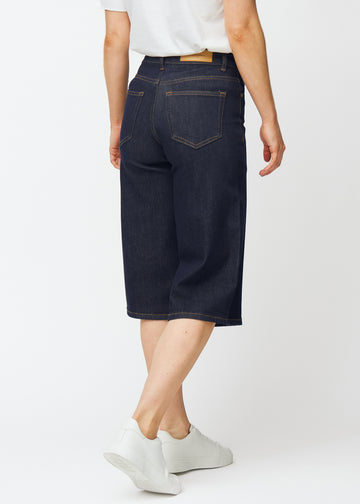 Deep dark blue denim capris for women in the colour Midnights seen from the back, showing the length below the knee.