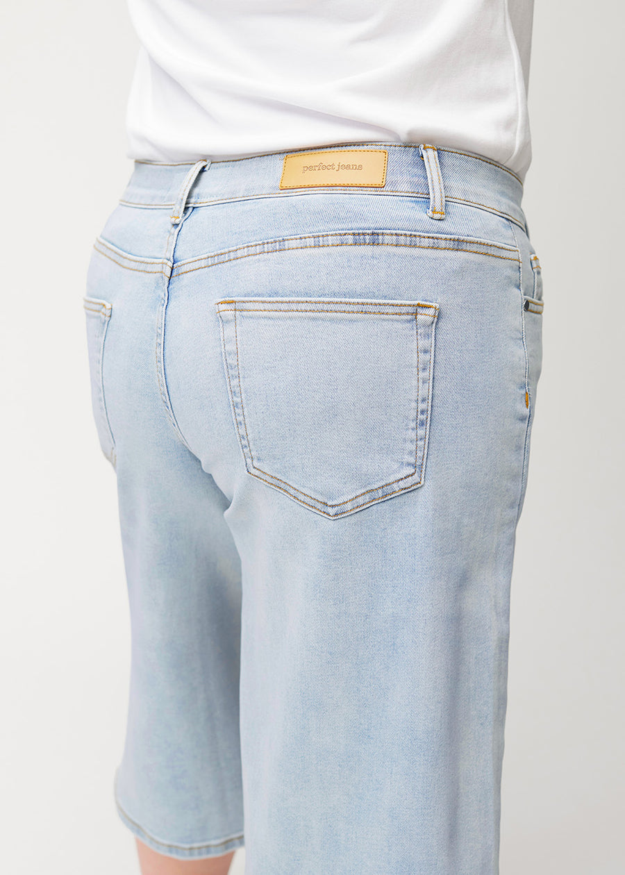 Løse, lyseblå denim capris i farven Waves set bagfra tæt på på plus-size model for at vise pasform og detaljer.