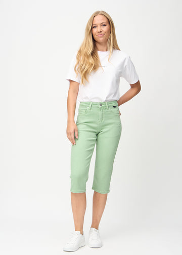 Full image of a model wearing light green regular capris.