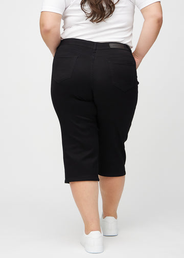 Black regular capris seen from the back on a plus-size model, so the entire product can be seen.