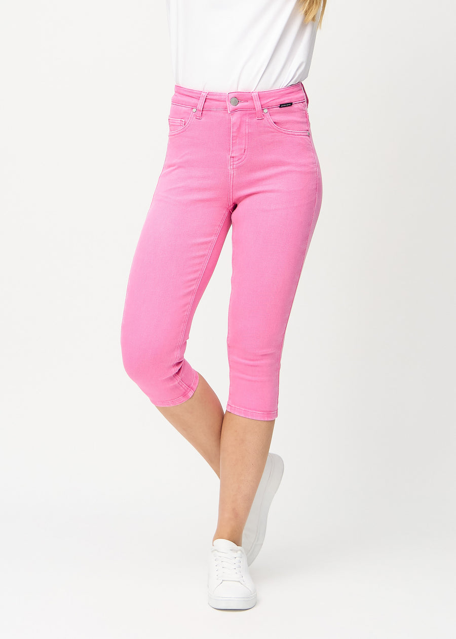 Skinny capris for women in pastel pink fabric, color Flamingos. Front view on a model, showing the close-fitting legs ending just below the knee.