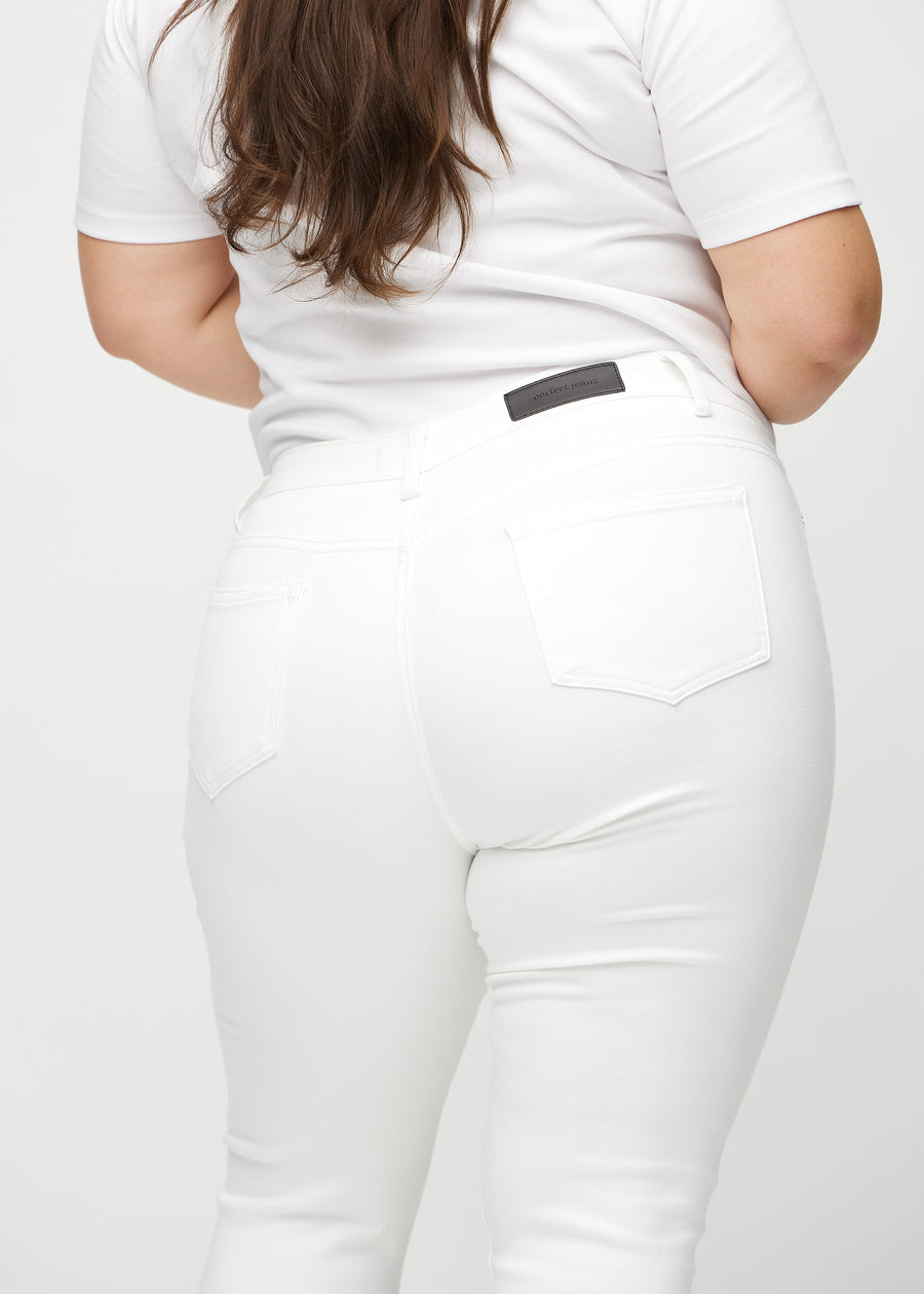 Skinny capris for women in white fabric, color Marguerites. Close-up from behind on a plus-size model, highlighting pockets and stitching.