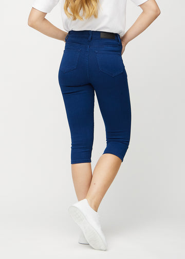 Skinny capris for women in dark blue fabric, color Royals. Back view on a model, showing the fit and back pockets.