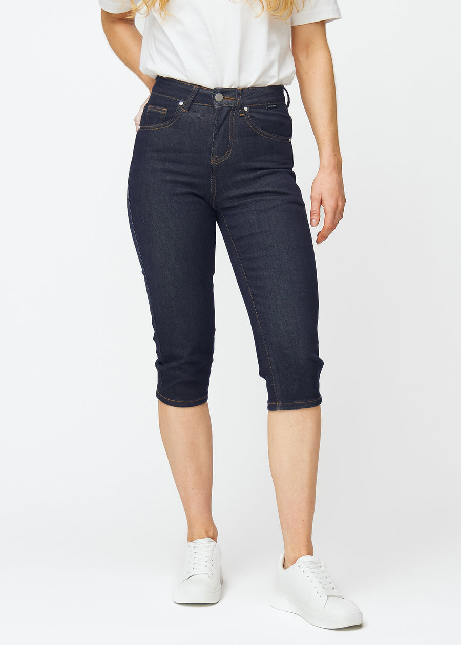 Deep dark blue denim capris for women in the colour Midnights with a slim fit, tailored from the hips to below the knee, seen from the front.