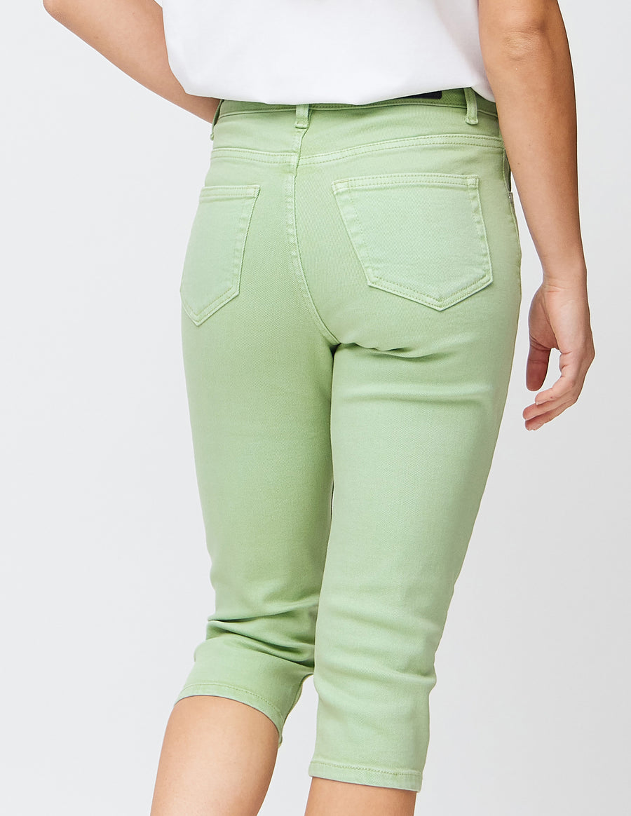 Slim capris for women in pastel light green jeans fabric, color Mints. Close-up from behind on a model, highlighting the back pockets and stitching.