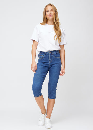Slim capris for women in dark blue denim, color Oceans. Full-length view of a model wearing slim capris.