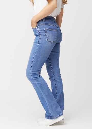 Blue mid-rise bootcut jeans in Rivers. Side view on a model.
