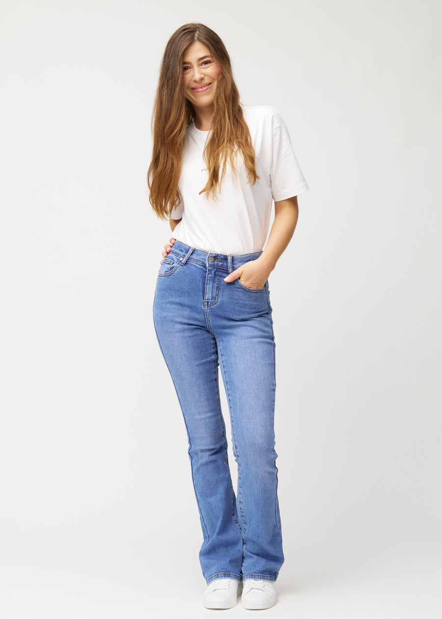 Blue mid-rise bootcut jeans in Rivers. Full-length view of a model wearing the jeans.