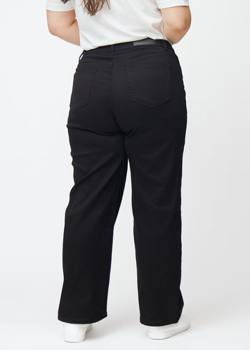 Black high-waisted jeans, which are fitted at the waist and have a loose fit with width down the leg, shown from the back on a plus-size model so you can see the full product.