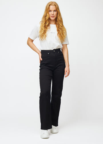 A full image of a model in black high-waisted jeans, which are fitted at the waist and have a loose fit with width down the leg.