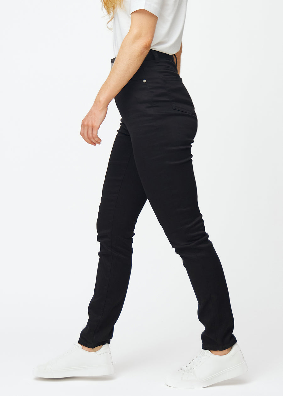 Black high-waisted slim jeans seen from the side on a model.