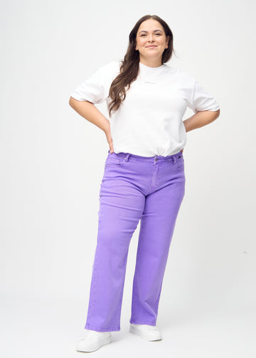 Loose jeans for women in purple, color Lavenders. Full-length view of a plus-size model wearing the loose-fit jeans.