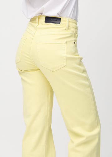 Loose jeans for women in light yellow, color Lemonades. Close-up from behind on a model, showing the fit and details.