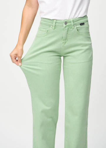 Loose jeans for women in light green, color Mints. A model stretches the denim at the thigh to show the fabric&