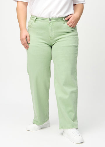 Loose jeans for women in light green, color Mints. Front view on a plus-size model, showing the roomy, wide-leg fit.