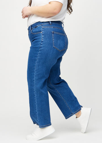 Dark denim loose jeans seen from the side on a plus-size model.