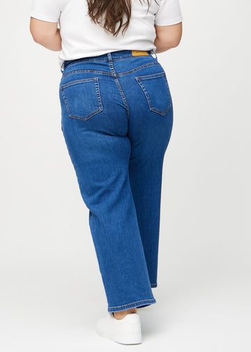 Dark denim loose jeans seen from the back on a plus-size model, so the entire product can be seen.