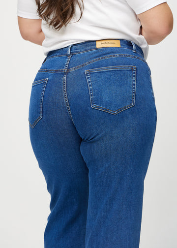 Dark denim loose jeans seen from the back close up on a plus-size model to show details.