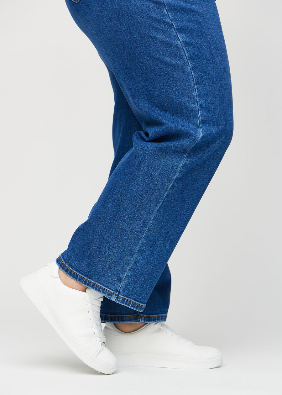The ankles of a plus-size model, so you can see how loosely the jeans fit.
