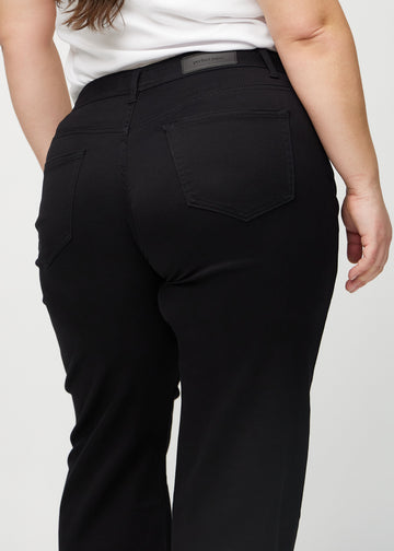 Black loose jeans seen from the back close up on a plus-size model to show details.