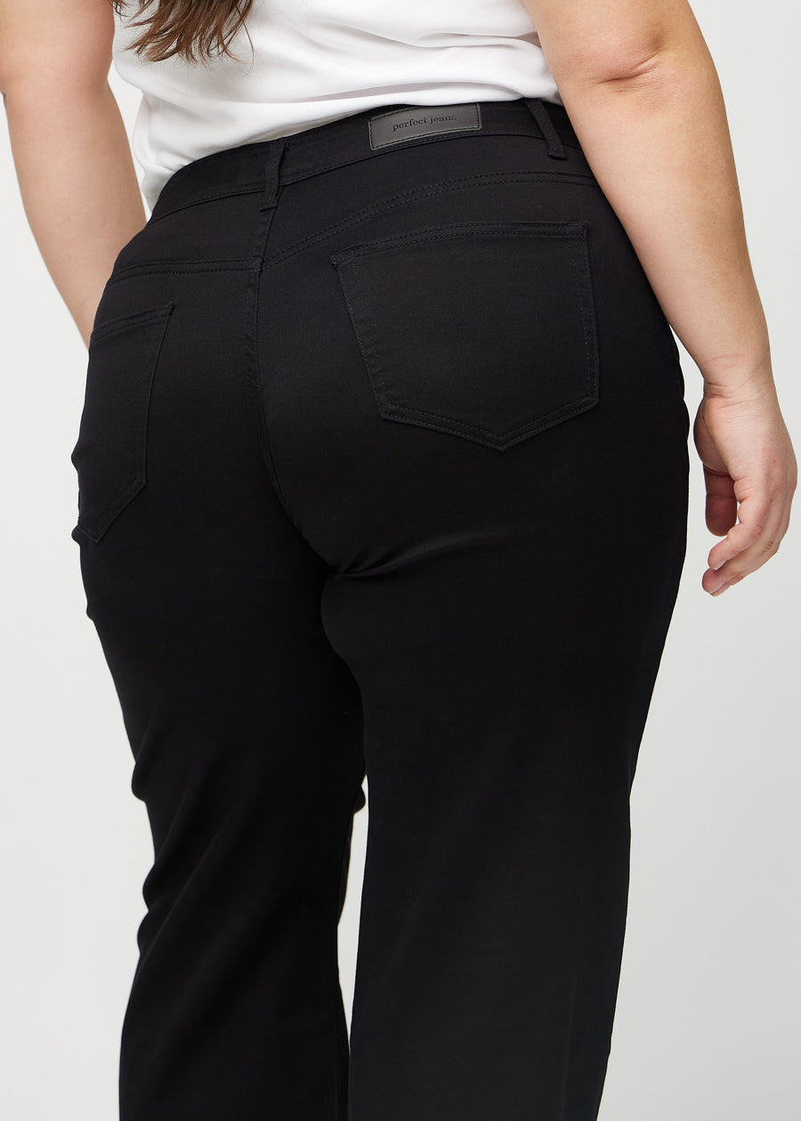 Black loose jeans seen from the back close up on a plus-size model to show details.