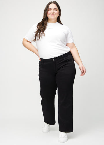 Full image of a plus-size model in black loose jeans.