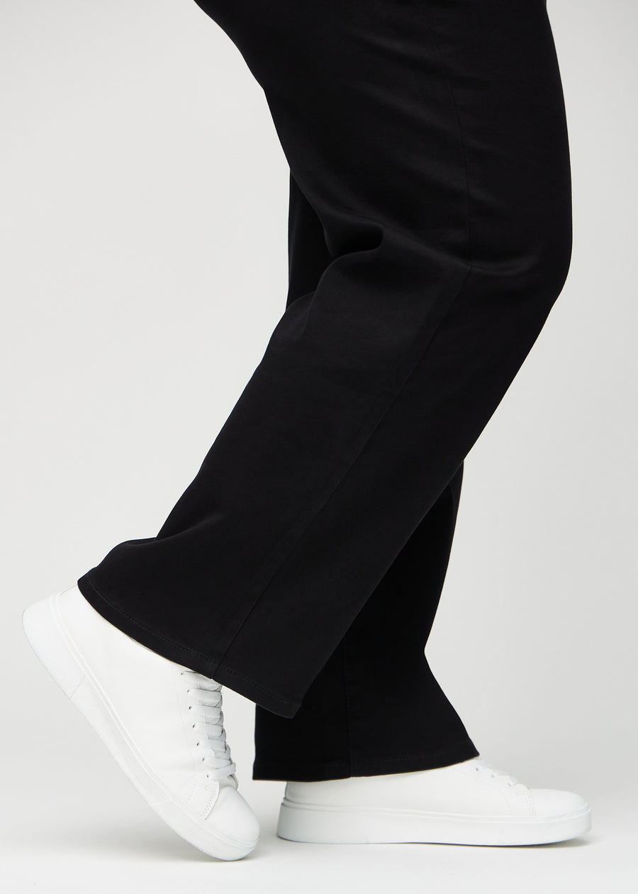 The ankles of a plus-size model, so you can see how loosely the jeans fit in a Loose fit.