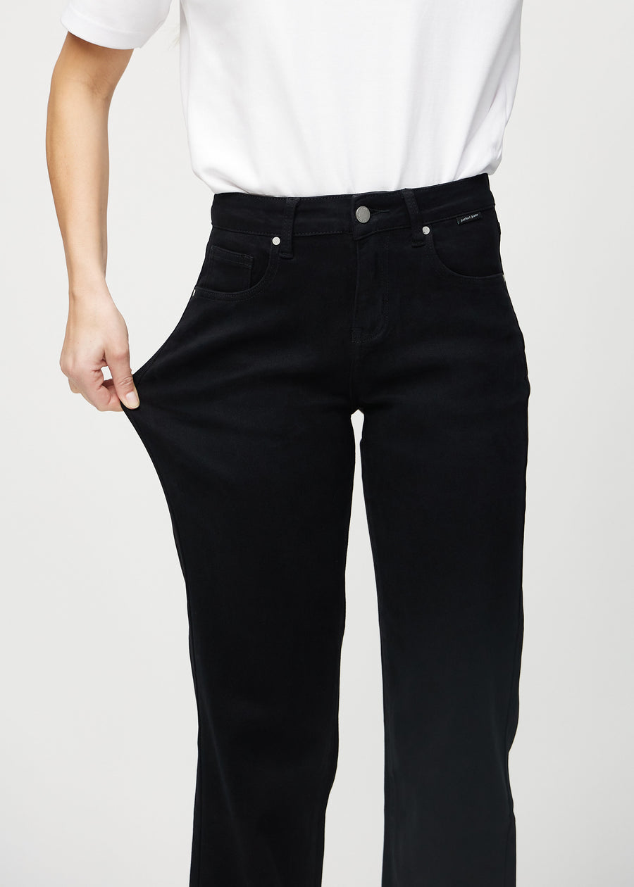 The model stretches the jeans at the thigh to show the stretch.