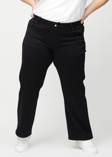 Black loose jeans, model name Ravens, which are loose-fitting with plenty of width in the legs on a plus-size model, seen from the front.