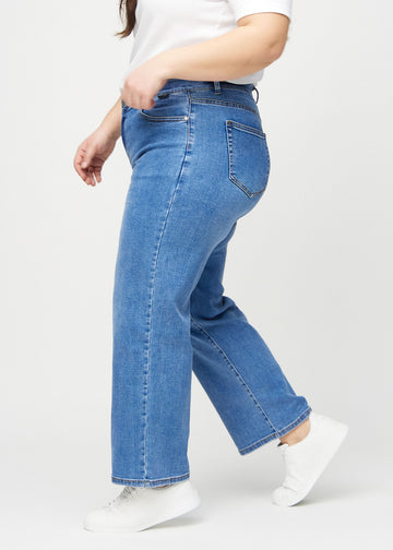 Loose jeans for women in blue, color Rivers. Side view on a plus-size model, showing the loose fit.