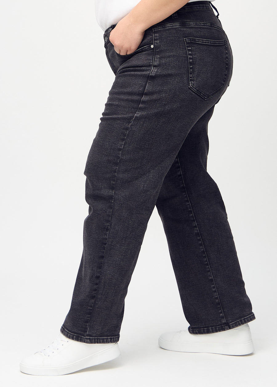 Loose jeans for women in dark grey, color Shadows. Side view on a plus-size model, showing the loose fit.