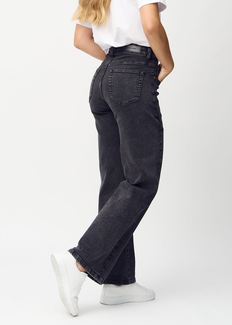 Loose jeans for women in dark grey, color Shadows. Back view on a model, showing the overall relaxed fit.