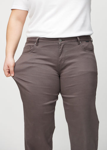 Loose jeans for women in grey-brown, color Thunders. A plus-size model stretches the denim at the thigh to show the fabric&